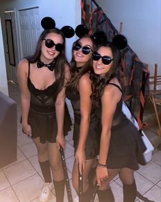 three girls dressed up as mickey mouse and minnie mouse ears, posing for the camera