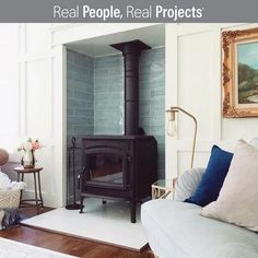 a living room filled with furniture and a wood burning stove in the middle of it