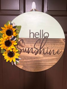 a wooden sign that says hello sunshine and two sunflowers on the front door