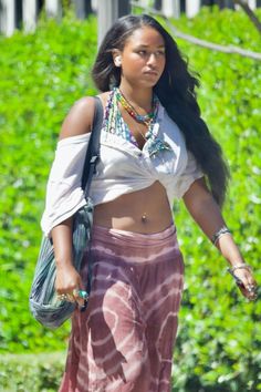 a woman walking down the street in a skirt