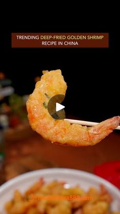 fried shrimp being held up by chopsticks over a bowl of food with the caption trending deep fried golden shrimp recipe in china