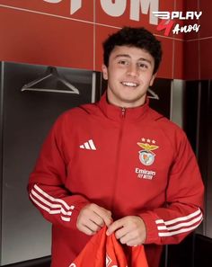 a young man holding a soccer jersey in his hands