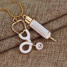 a pair of scissors and a needle on a gold necklace