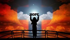 a person holding up a sign that says hope in front of an orange and blue sky