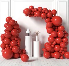 red balloons are arranged in the shape of an o - shaped arch and vases