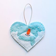 an ornament shaped like a heart with a fish on it