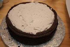 a chocolate cake with white frosting on a silver plate