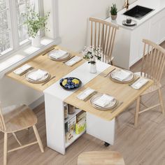 a kitchen table with chairs and plates on it