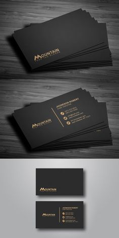 some black and gold business cards on top of a wooden table, with the words mountain written