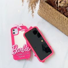 two cell phones sitting next to each other on top of a white table with a basket in the background