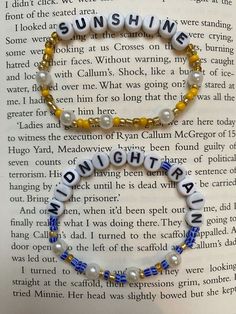 a book with some beads on it and the words sunshine written in white, yellow and blue