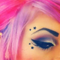 a woman with pink hair has stars on her face