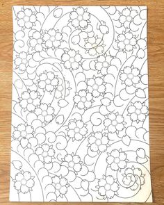 a piece of paper that has been drawn on top of it, with flowers and swirls