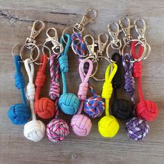 there are many different types of keychains on the wooden table with each other