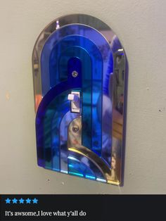 a blue glass clock mounted to the side of a wall