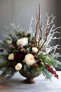 a vase filled with white flowers and greenery