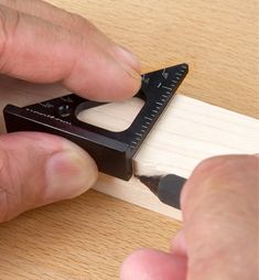 a man is using a ruler to cut wood