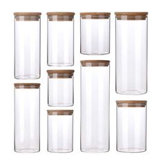 six glass jars with wooden lids are stacked on top of each other and one is empty