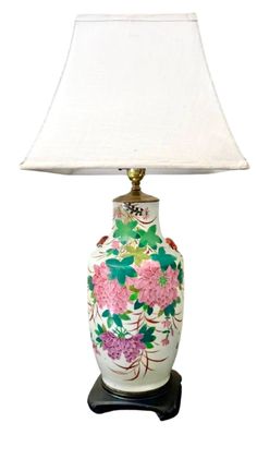 a white lamp with pink flowers on it and a white shade over the light fixture