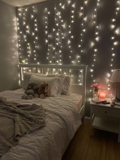 a bedroom with lights on the wall and a teddy bear