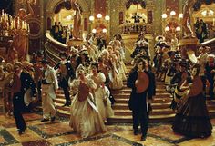 a group of people dressed in fancy clothing standing on a staircase with chandeliers