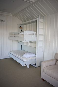 a bunk bed sitting in the corner of a room next to a couch and chair