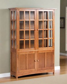 a wooden bookcase with glass doors in a room