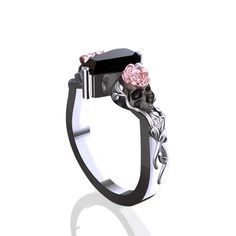 a black and white skull ring with pink roses on the side, sitting against a white background