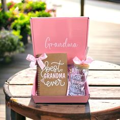 a pink box filled with gifts sitting on top of a wooden table