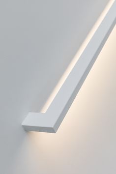 a close up of a light on a wall with a white finish and dim lighting