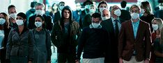 a group of people wearing masks walking down a street