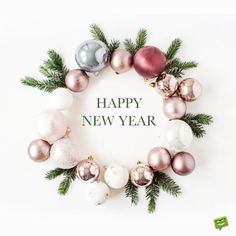 a christmas wreath with ornaments and the words happy new year