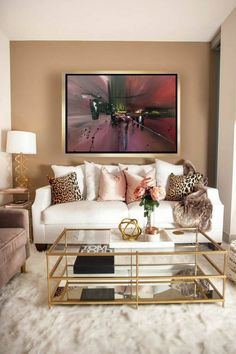 a living room with white couches and leopard print pillows on the back of them