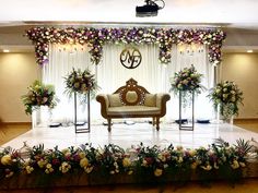 an elegant stage set up with flowers and greenery for a wedding or special event