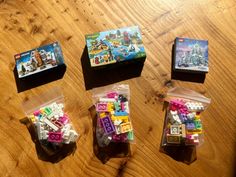 three legos are sitting on the table in plastic bags and some sort of building blocks