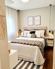 a bedroom with a large bed and two pictures on the wall above it's headboard