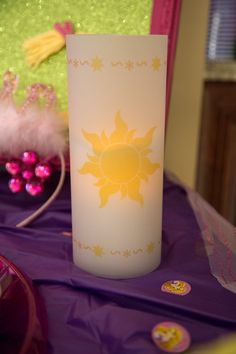 a lit candle sitting on top of a purple table