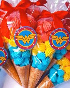 there are many cupcakes in the shape of superman and wonder woman's logos