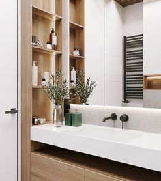 a bathroom with wooden shelves and white counter tops, along with a large mirror on the wall