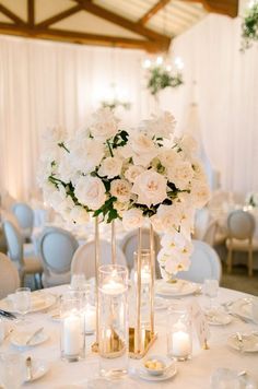 the centerpieces are filled with white flowers and candles