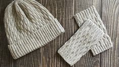 two knitted hats and mittens sitting on top of a wooden floor next to each other