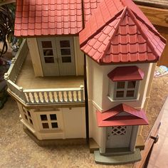 a toy house with a red roof on a table