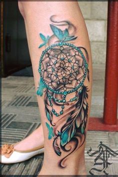 a woman's leg with a tattoo on it and a blue dream catcher in the center