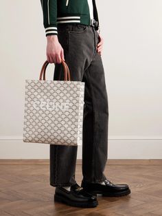 CELINE HOMME's tote is patterned with its signature 'Triomphe' motif – inspired by the famous Parisian landmark – and branded with the house logo, so it feels both classic and cool. It’s made from hard-wearing coated-canvas with supple leather straps and has a lined interior that’s sized to fit all of your essentials. Secure your small items in the internal zipped pocket. Designer Monogram Print Tote Bags, Designer Monogram Print Shoulder Bag For Shopping, Luxury White Bag With Monogram Print, Luxury Monogram Print Shoulder Bag For Shopping, Monogram Print Tote Bag, Rectangular Shopping Bag With Monogram Print, Rectangular Monogram Print Shopping Bag, Rectangular Monogram Print Bag, Top Handle Shoulder Bag With Monogram Print For Shopping