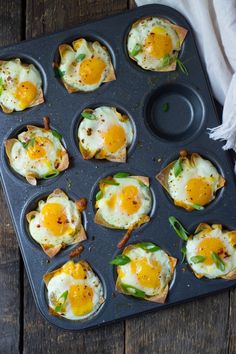 eggs are in muffin tins with green peppers and other toppings on them