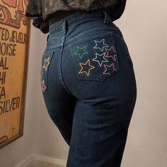 "Reworked Rainbow Star Jeans by Sensible Slacks. A pair of vintage high rise Sassoon jeans reworked and upcycled with embroidered rainbow star pockets.  The embroidered stars add a subtle touch of celestial style. These jeans evoke playful vintage styles, while maintaining the low-waste and slow fashion values that reworked clothing is known for. Sustainable fashion does not need to be boring!   Pockets are fully functional- they can be used freely.  Jeans are 100% cotton, made in Mexico. Marked Pant Pocket Painting, Jeans Back Pocket Embroidery, Star Embroidery Jeans, Back Pocket Designs Jeans Painting, Painting On Jeans Pocket, Paint Jeans Ideas, Swaggy Pants, Jean Embroidery Ideas, Jean Pocket Painting