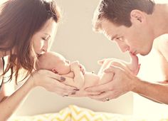 a man and woman holding a baby in their hands