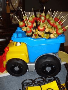 a toy truck filled with fruit on top of a table