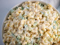 a white bowl filled with macaroni salad on top of a table