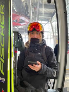 a woman in ski gear holding a cell phone